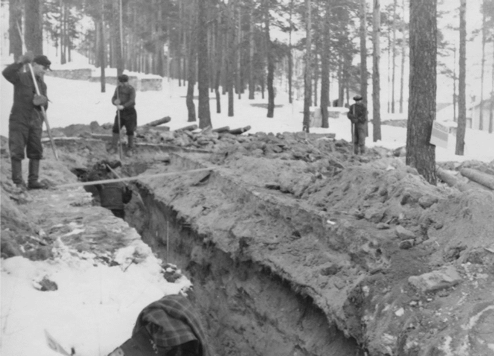 Mustavalkokuva miehistä kaivamassa maata